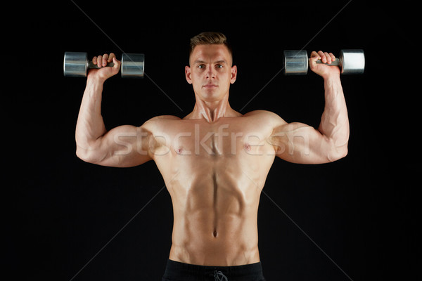 man bodybuilder with dumbbells exercising Stock photo © dolgachov
