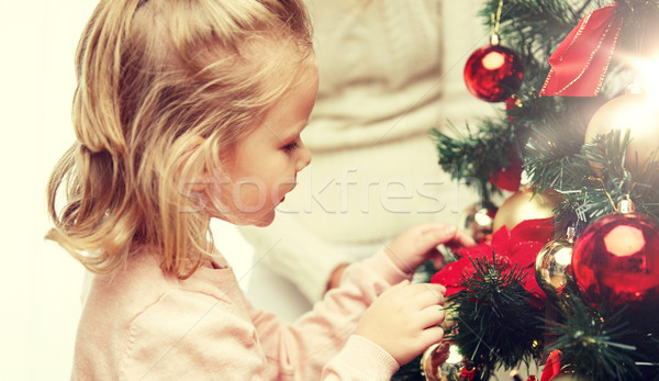 little girl decorating christmas tree at home Stock photo © dolgachov