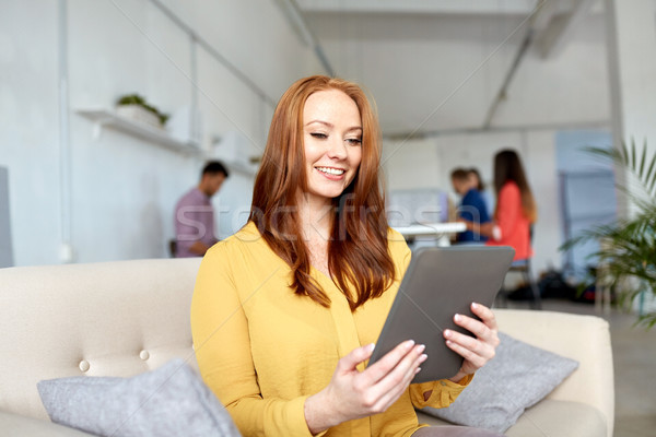 redhead woman with tablet pc working at office Stock photo © dolgachov