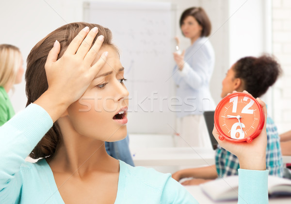 attractive student looking at clock Stock photo © dolgachov