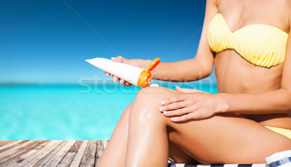 Stock photo: girl putting sun protection cream on berth