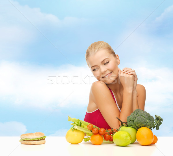 doubting woman with fruits and hamburger Stock photo © dolgachov