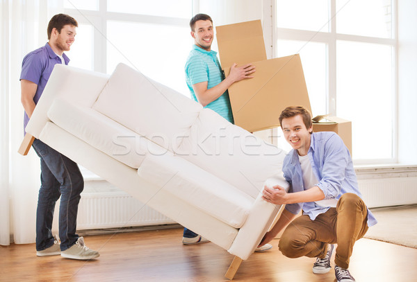 smiling friends with sofa and cardboard boxes Stock photo © dolgachov