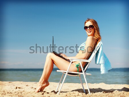smiling young woman sunbathing in lounge on beach Stock photo © dolgachov