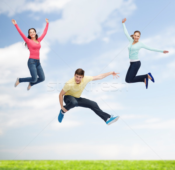 group of smiling teenagers jumping in air Stock photo © dolgachov