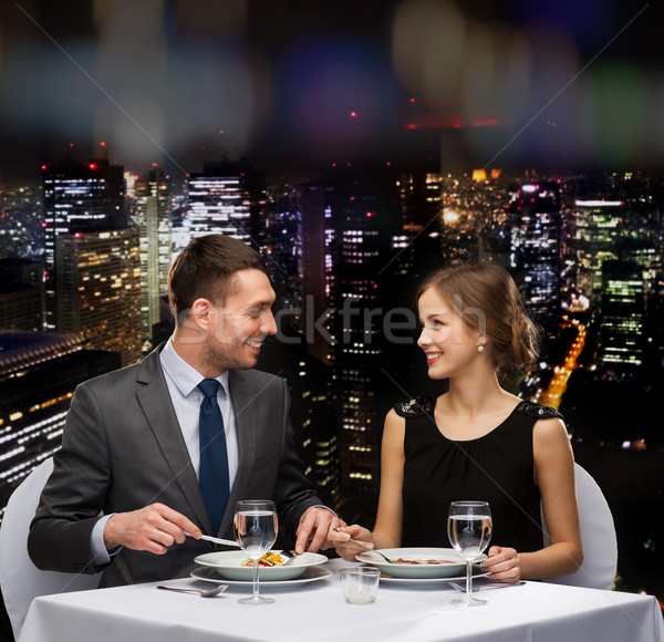 smiling couple eating main course at restaurant Stock photo © dolgachov