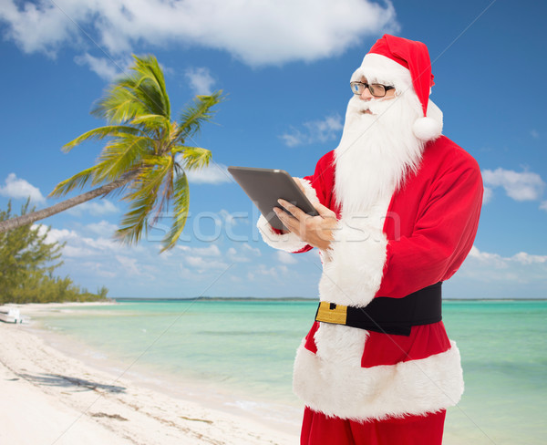 man in costume of santa claus with tablet pc Stock photo © dolgachov