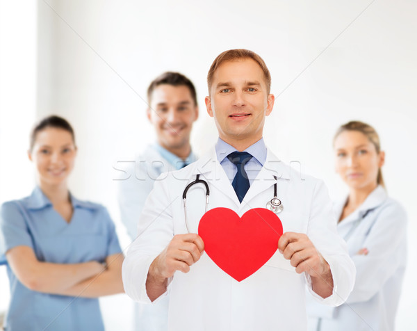 smiling male doctor with red heart and stethoscope Stock photo © dolgachov