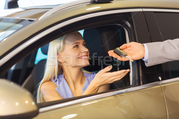 happy woman getting car key in auto show or salon Stock photo © dolgachov