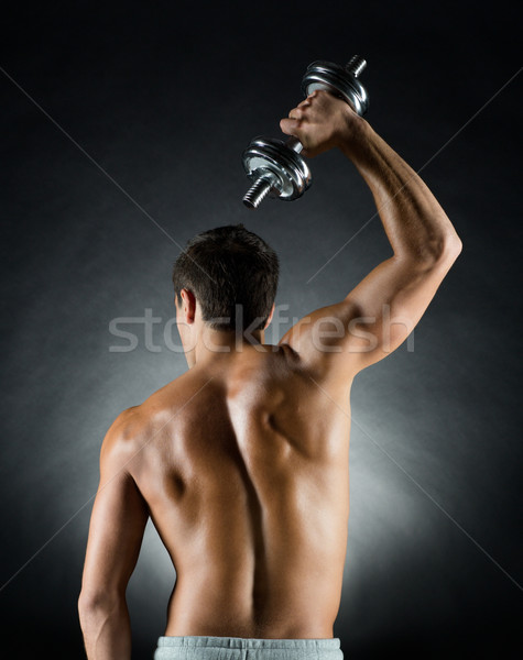 young man with dumbbell Stock photo © dolgachov