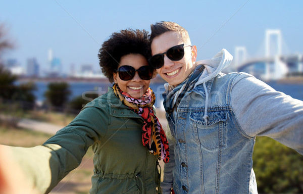 happy teenage couple taking selfie in tokyo Stock photo © dolgachov