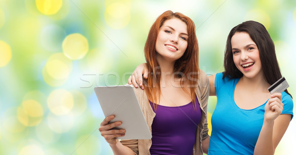 two smiling girls with tablet pc and credit card Stock photo © dolgachov