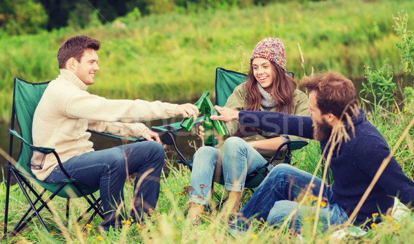 Stock photo: group of smiling tourists drinking beer in camping