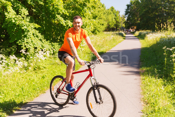 happy young man riding bicycle outdoors Stock photo © dolgachov