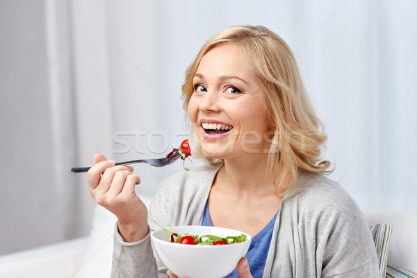 smiling middle aged woman eating salad at home Stock photo © dolgachov