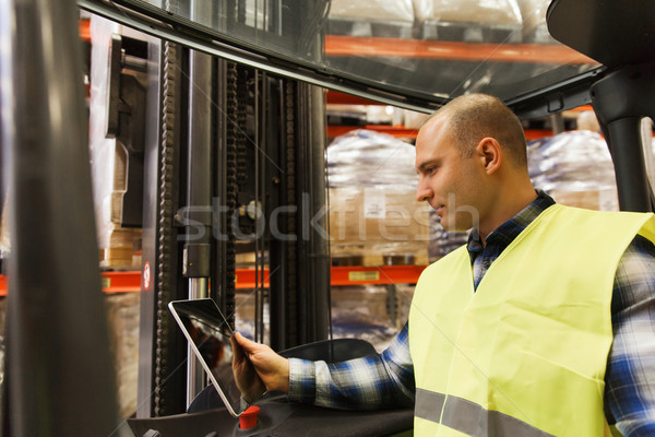 man with tablet pc operating forklift at warehouse Stock photo © dolgachov