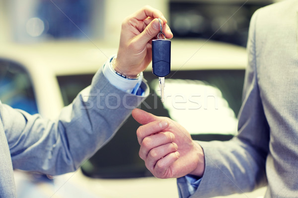 close up of male hands with car key in auto salon Stock photo © dolgachov