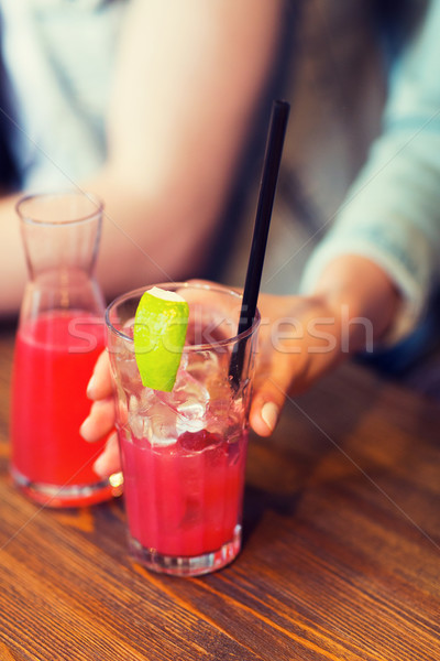 close up of hand with cocktail or juice and straw  Stock photo © dolgachov