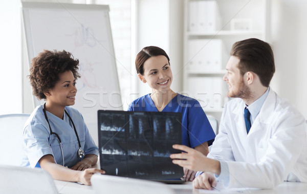 Groep gelukkig artsen bespreken Xray afbeelding Stockfoto © dolgachov