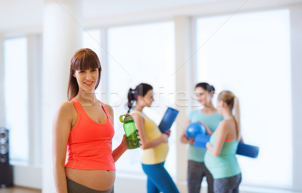 Heureux femme enceinte une bouteille d'eau gymnase grossesse sport [[stock_photo]] © dolgachov