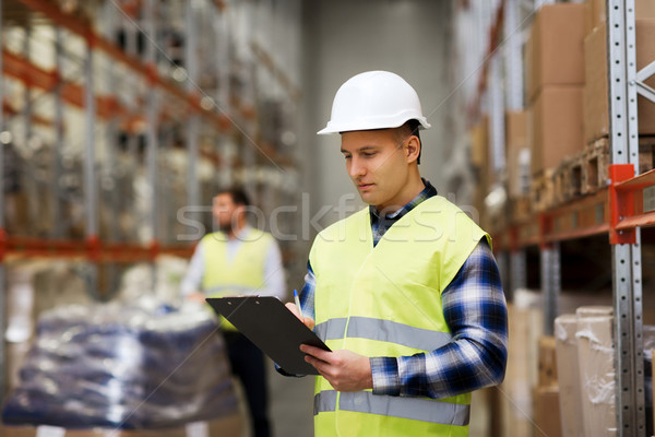 man with clipboard in safety vest at warehouse Stock photo © dolgachov