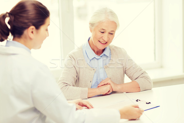 doctor with clipboard and senior woman at hospital Stock photo © dolgachov