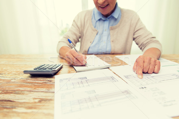 senior woman with papers and calculator at home Stock photo © dolgachov