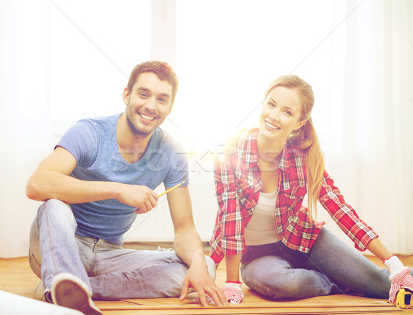 smiling couple measuring wood flooring Stock photo © dolgachov