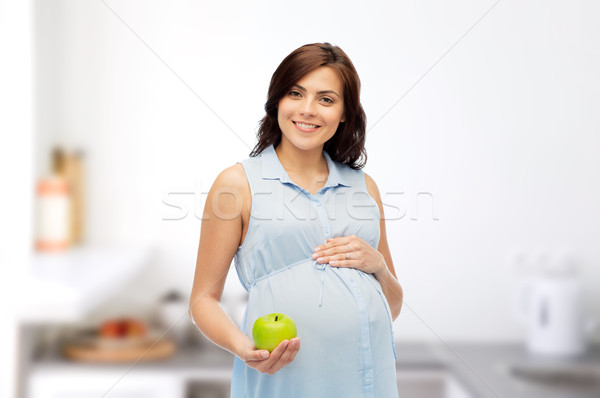 happy pregnant woman holding green apple Stock photo © dolgachov