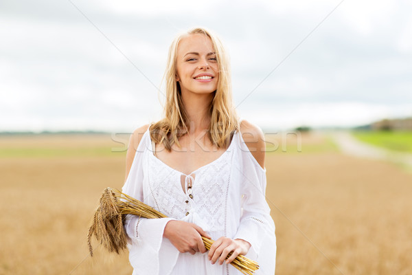 happy young woman with spikelets on cereal field Stock photo © dolgachov