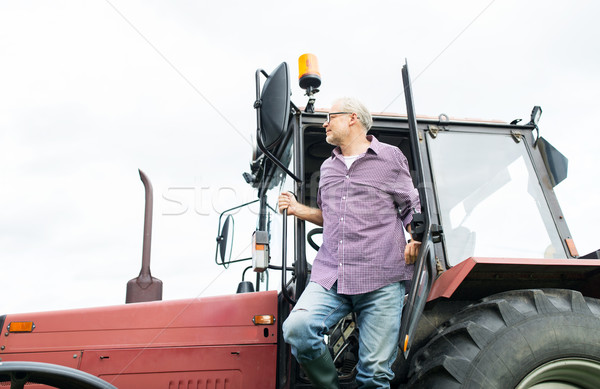 Stary rolnik na zewnątrz ciągnika gospodarstwa Zdjęcia stock © dolgachov
