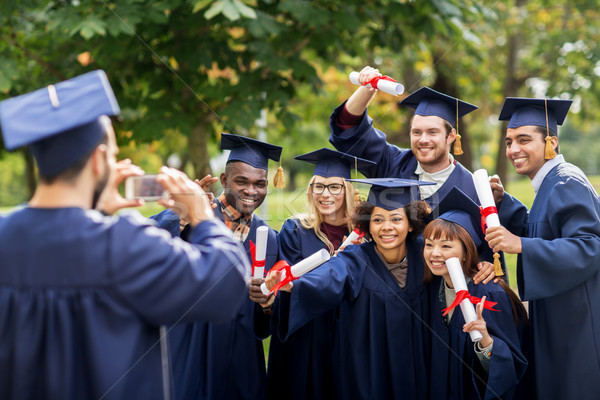 students or bachelors photographing by smartphone Stock photo © dolgachov