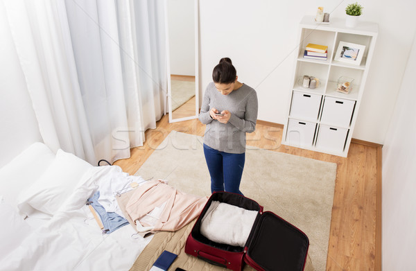 Stock photo: woman packing travel bag at home or hotel room