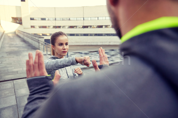 woman with trainer working out self defense strike Stock photo © dolgachov