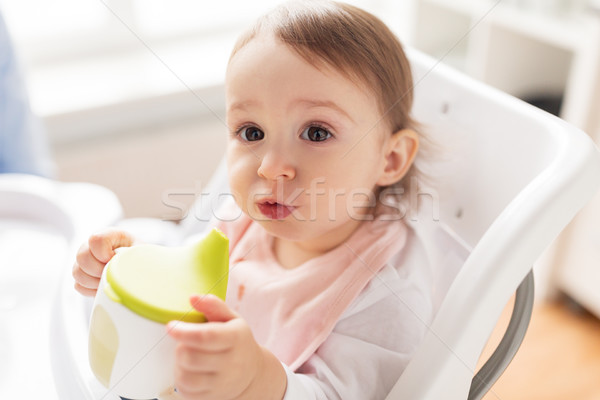 baby drinking from spout cup in highchair at home Stock photo © dolgachov