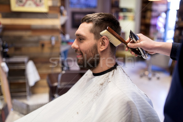 Man And Barber With Brush Cleaning Hair At Salon Stock Photo