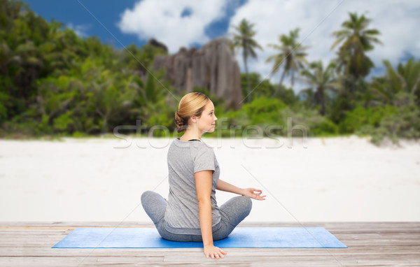 Stock photo: woman doing yoga in twist pose on beach