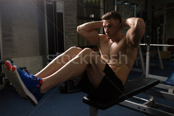 young man doing sit-up abdominal exercises in gym Stock photo © dolgachov