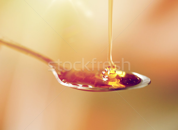 close up of honey pouring to teaspoon Stock photo © dolgachov