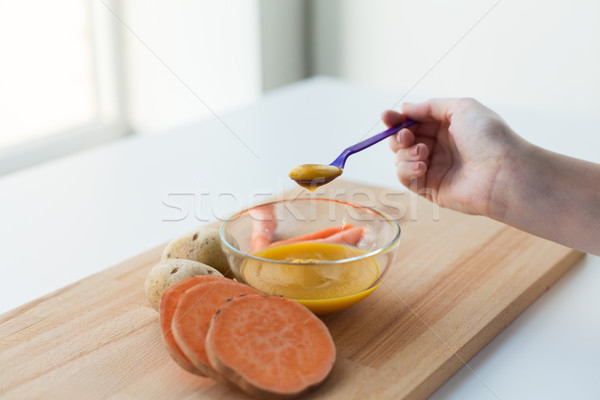hand with vegetable puree or baby food in spoon Stock photo © dolgachov