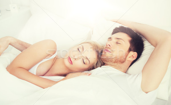 happy couple sleeping in bed at home Stock photo © dolgachov