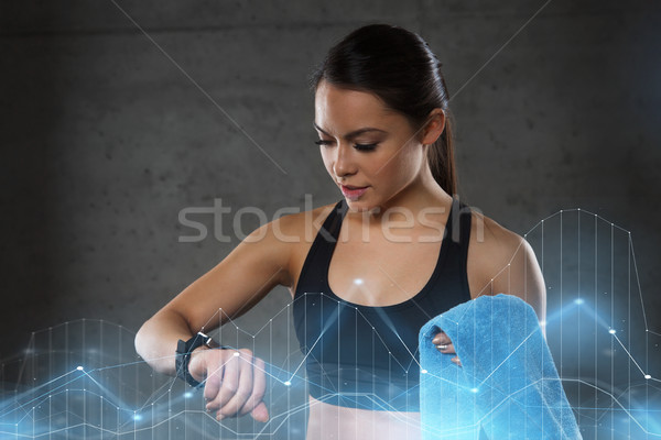 young woman with heart-rate watch and towel in gym Stock photo © dolgachov