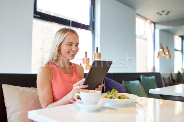 happy young woman with tablet pc at restaurant Stock photo © dolgachov