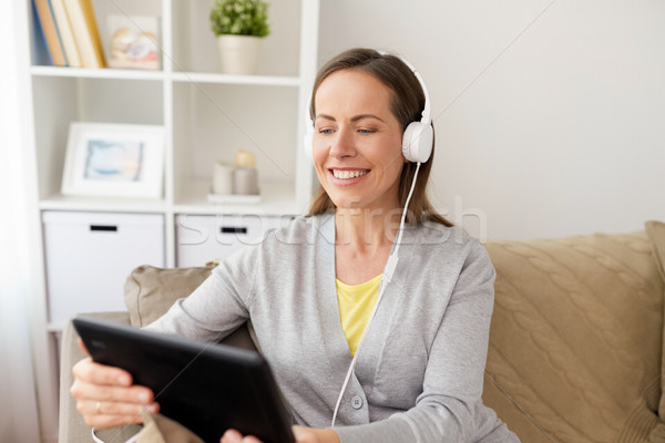 happy woman with tablet pc and headphones at home Stock photo © dolgachov