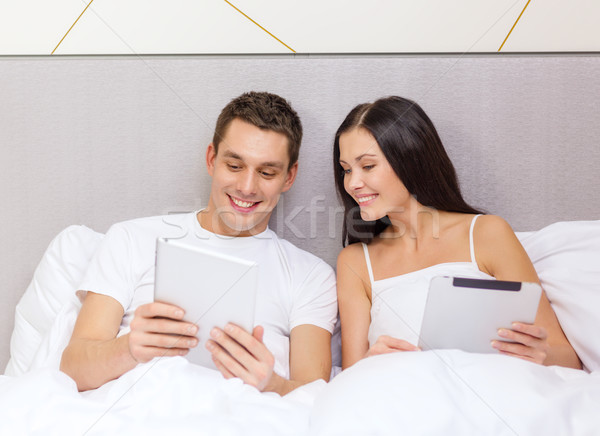 smiling couple in bed with tablet pc computers Stock photo © dolgachov