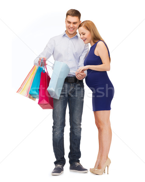 Stock photo: happy family expecting child with shopping bags