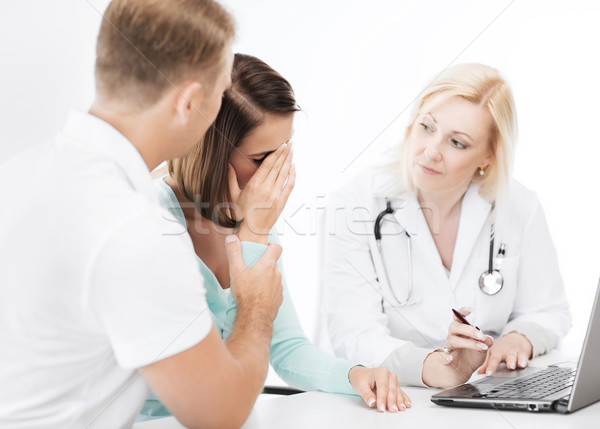 doctor with patients looking at laptop Stock photo © dolgachov