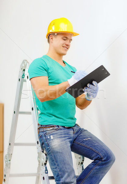 Souriant homme casque presse-papiers réparation bâtiment Photo stock © dolgachov