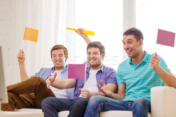 happy male friends with flags and vuvuzela Stock photo © dolgachov