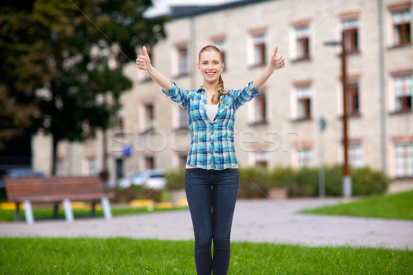 smiling girl in casual clothes showing thumbs up Stock photo © dolgachov